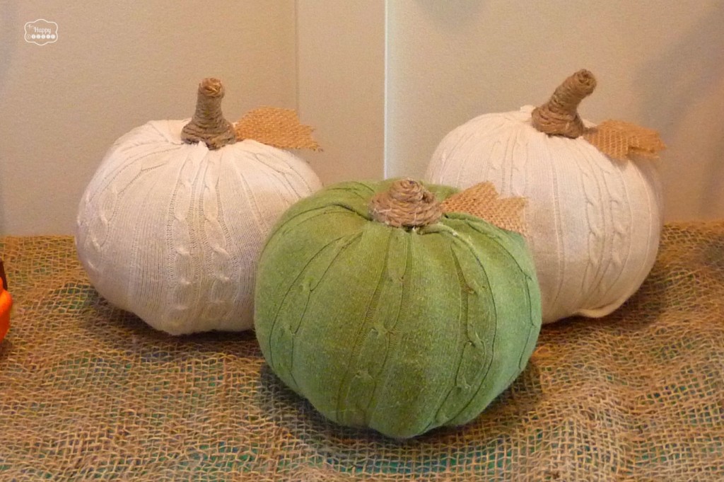 Three sweater pumpkins sitting on burlap.