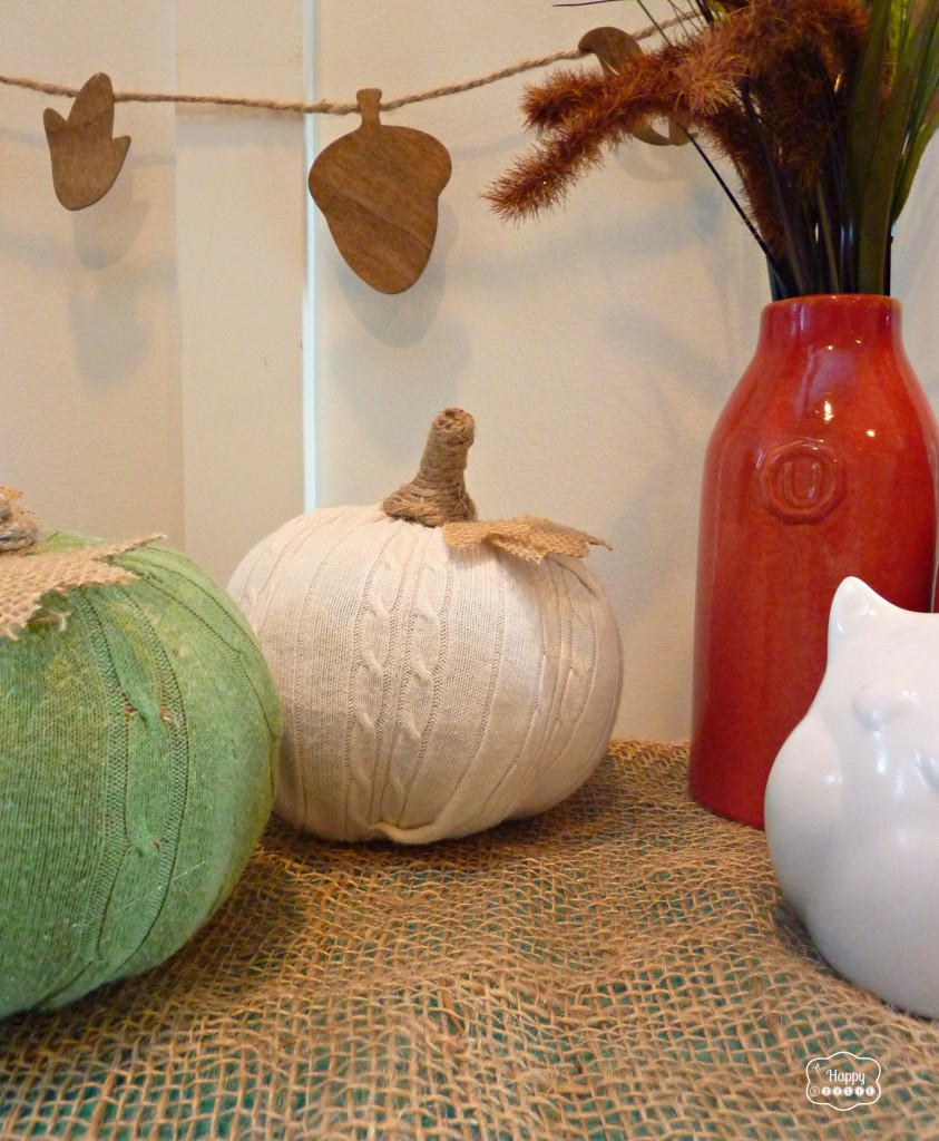 The sweaters pumpkins by a banner of acorns.