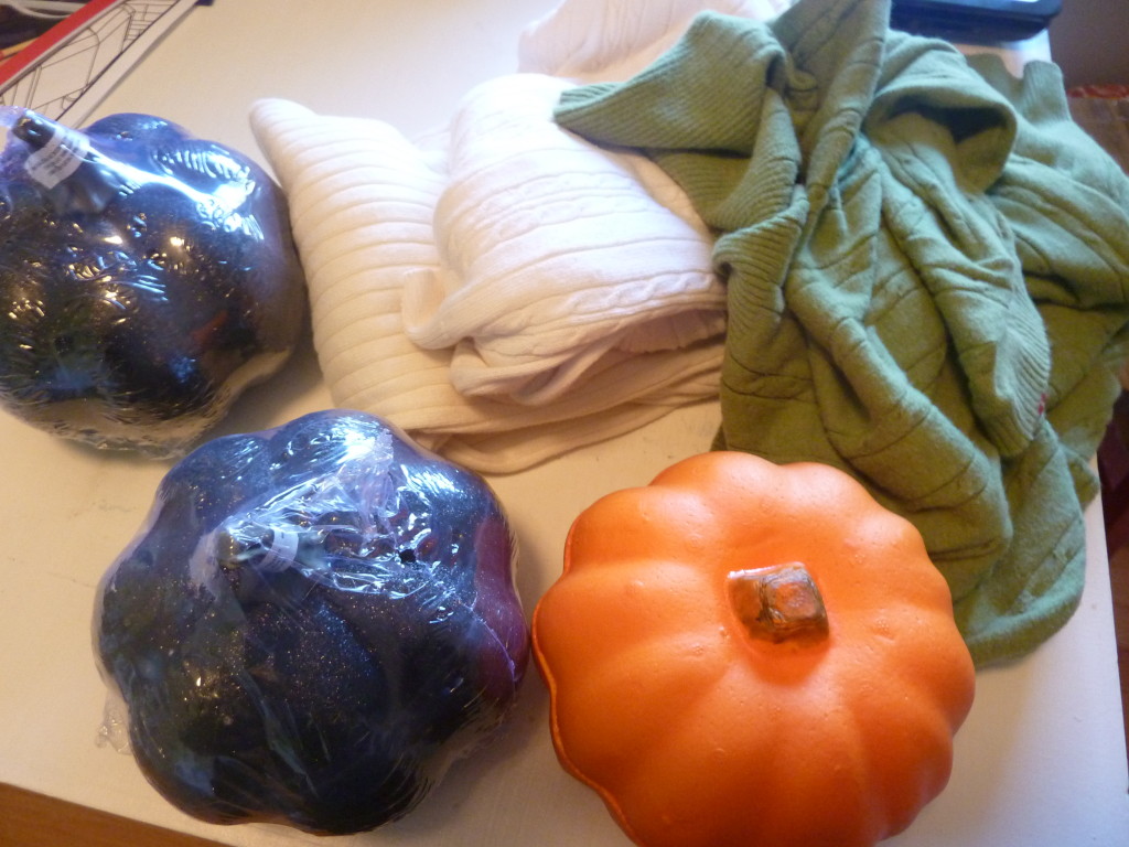 Foam pumpkins and old sweaters on the table.