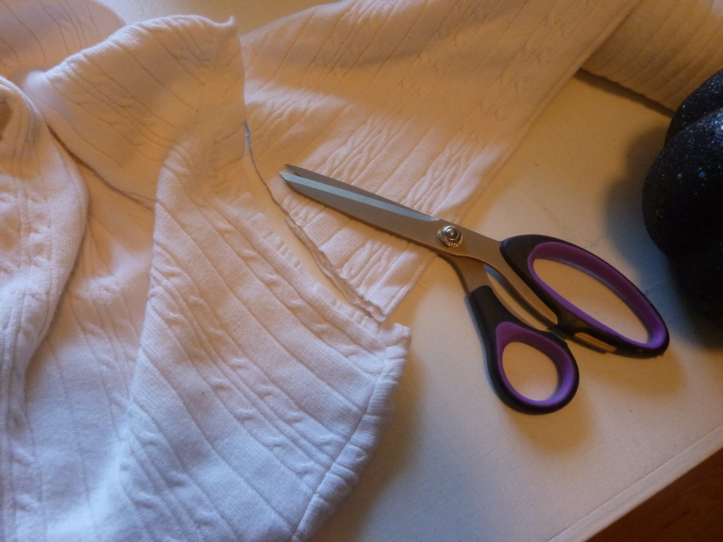 Cutting the sleeves off the old white sweater.