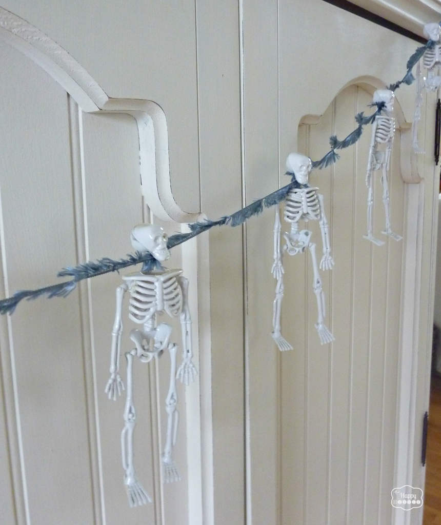 Thrifty Halloween Mantel with white skeleton bunting at thehappyhousie