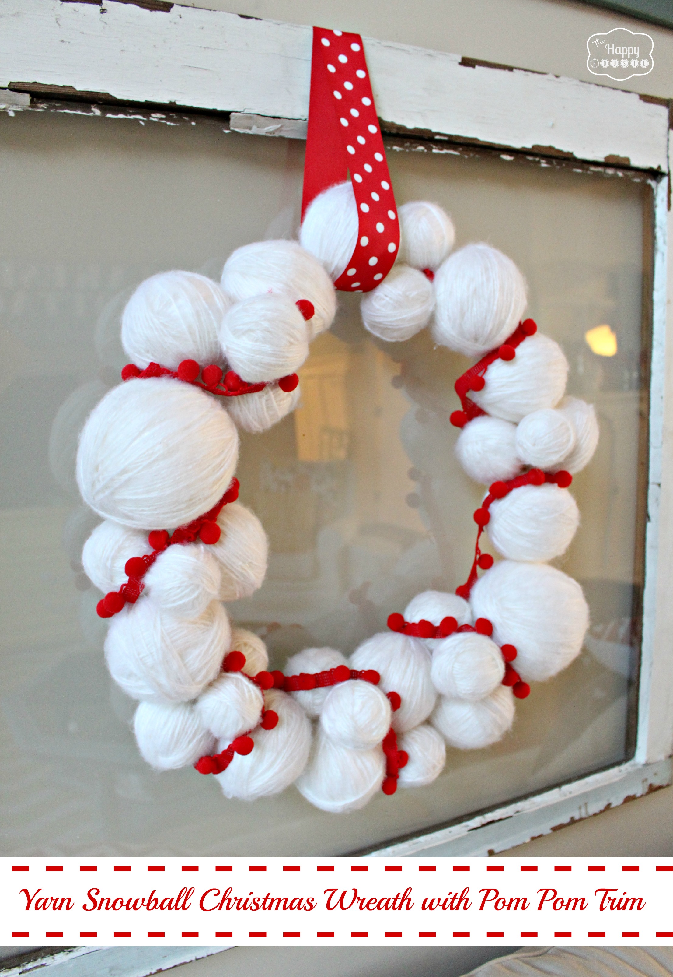 Yarn snowball christmas wreath with pom pom trim.