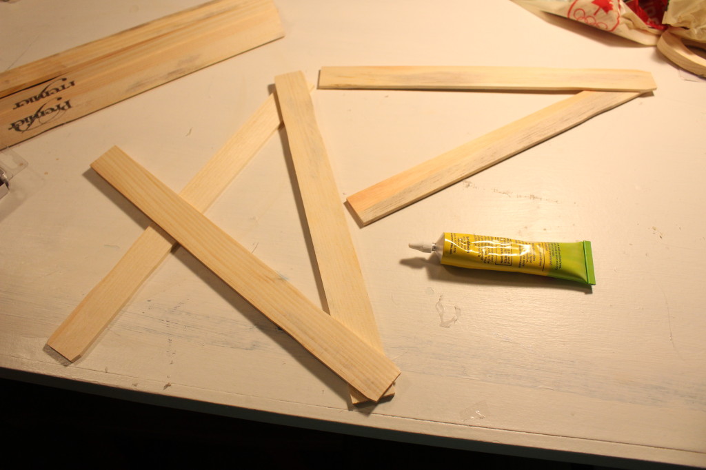 The glue and wooden sticks on the table.