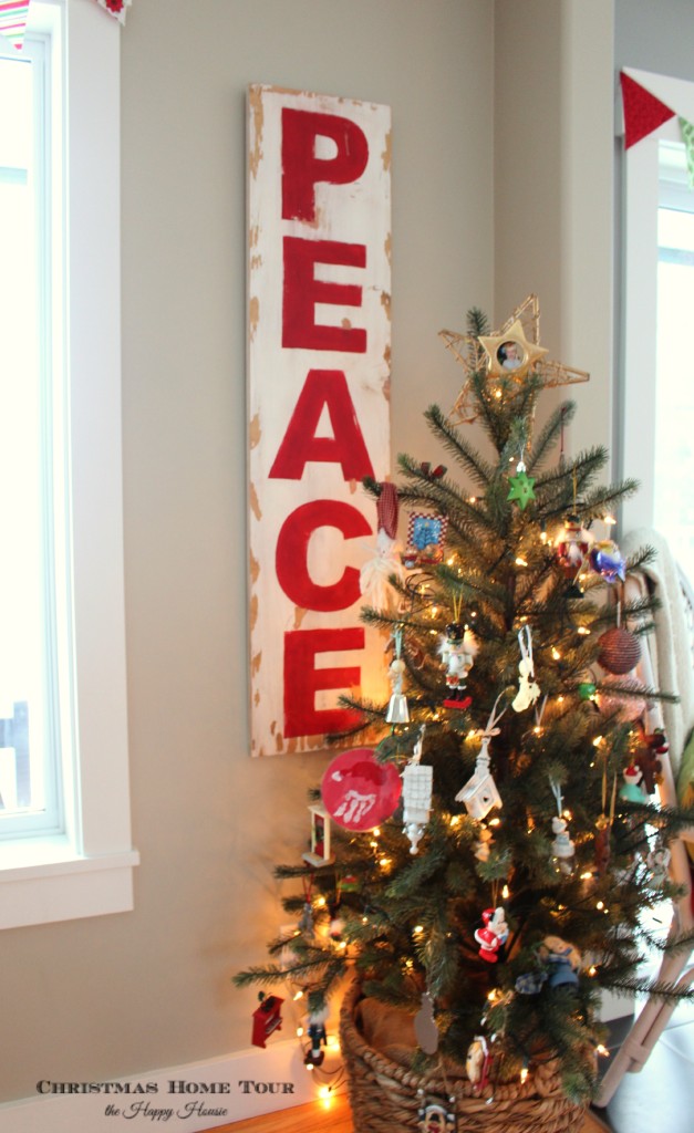 The peace sign hanging in the living room behind the Christmas tree.