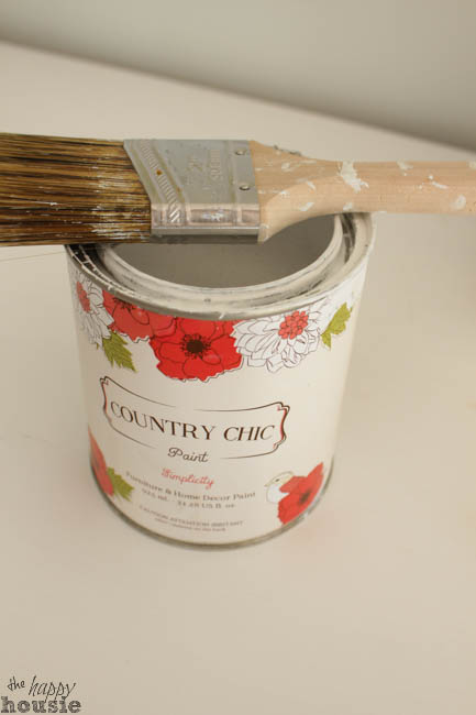 Can of Country Chic paint, with brush on top of it.
