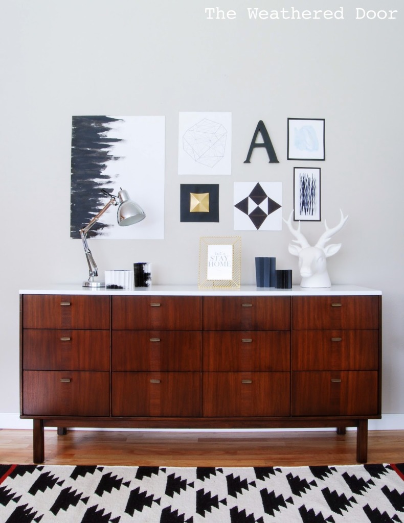 Danish modern credenza with a black and white rug in a geometrical pattern.