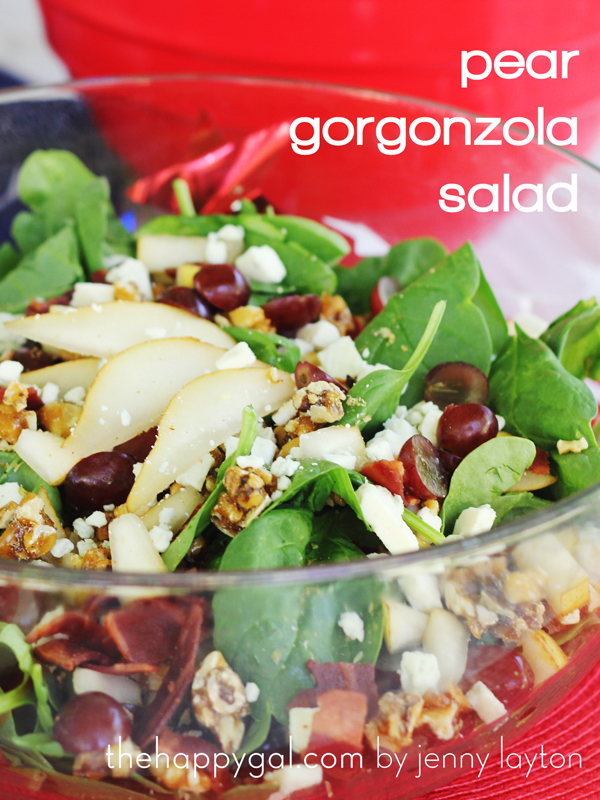Pear gorgonzola salad in a clear bowl with spinach as well.