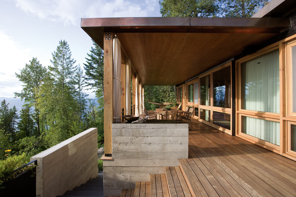 A neutral sparse wooden deck overlooking a forest.